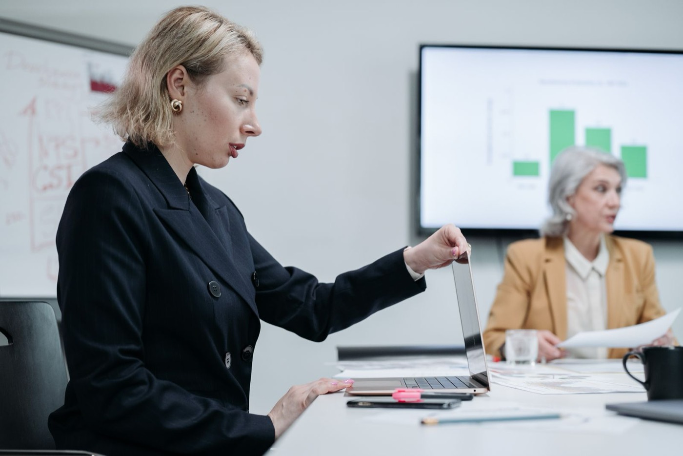 Dos profesionales revisando resultados en una sala de reuniones, con un gráfico proyectado en la pantalla